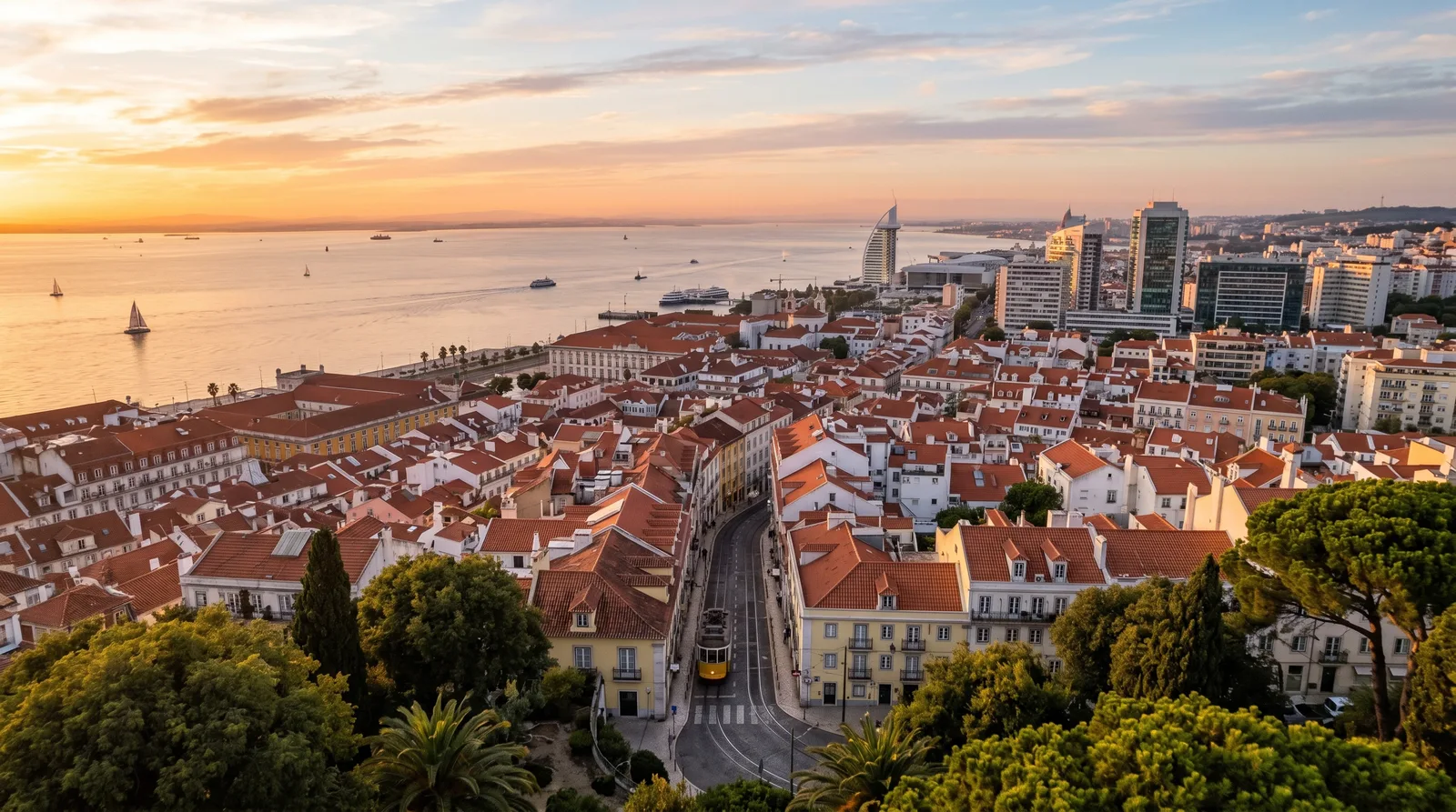 Aerial view of Lisbon at golden hour showing terracotta rooftops and the Tagus River